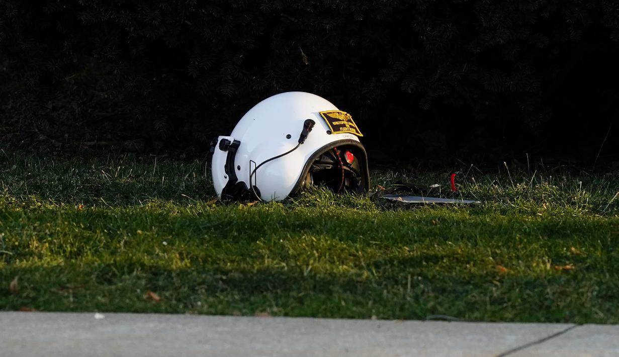 Sebuah helm tergeletak di tanah dekat lokasi helikopter medis yang jatuh di dekat Gereja Drexel Hill United Methodist Church di Drexel Hill, Philadelphia, Pennsylvania, AS (11/1/2022). Helikopter medis yang akan menuju keluar negara AS terjatuh di dekat gereja. (AP Photo/Matt Rourke)