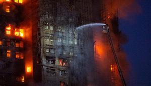 Para petugas pemadam berusaha memadamkan kebakaran yang terjadi di Wang Fuk Court, sebuah kompleks apartemen di Distrik Tai Po, New Territories, Hong Kong, Rabu (26/11/2025). (Dok. AP/Chan Long Hei)