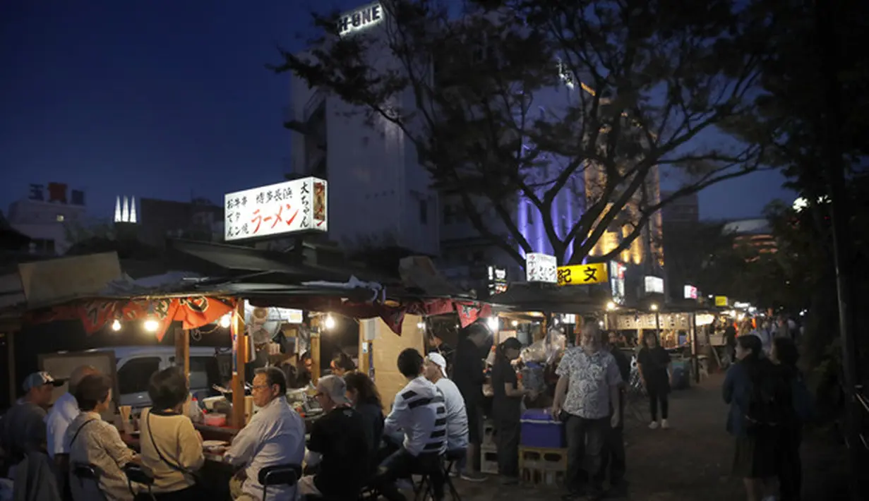 Orang-orang menikmati makan malam di stand makanan terbuka (Yatai) di Fukuoka, Jepang barat daya (30/9/2019). Yatai umumnya dapat menampung sekitar tujuh atau delapan orang. (AP Photo/Christophe Ena)