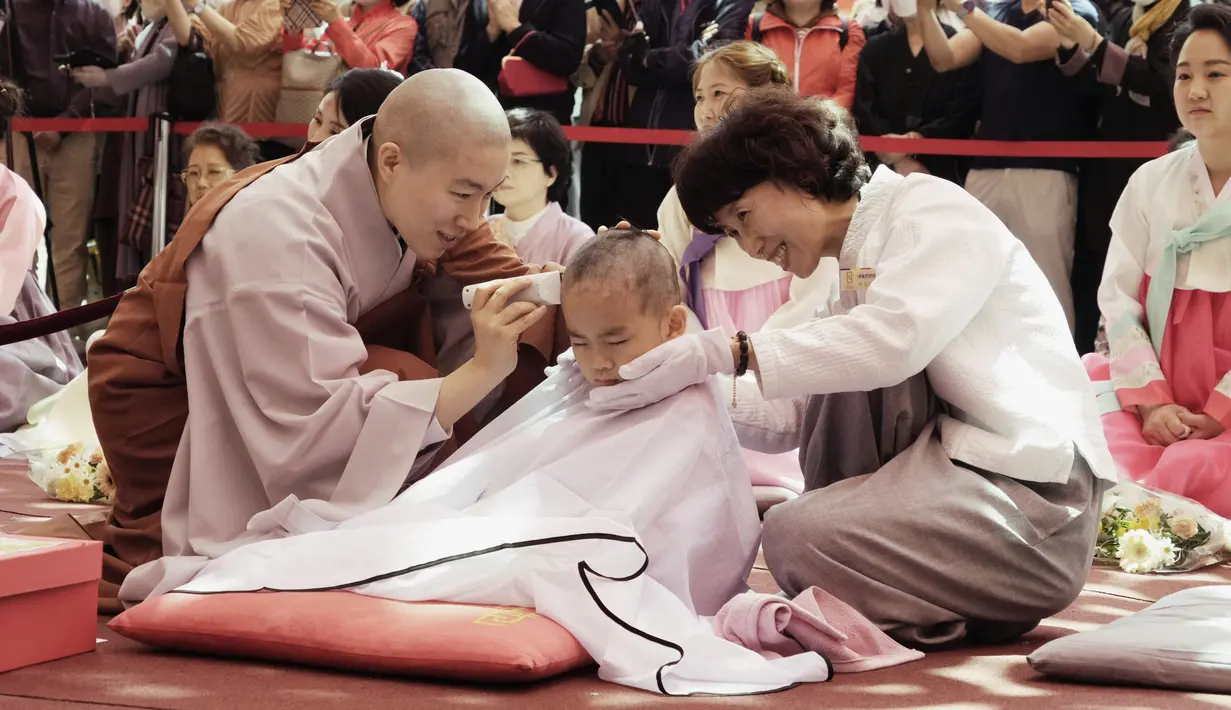 <p>Seorang biksu mencukur rambut anak laki-laki dalam sebuah acara kebaktitan di Kuil Jogye di Seoul, Korea Selatan, Selasa, 9 Mei 2023. (AP Photo/Ahn Young-joon)</p>