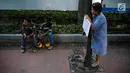 Seorang wanita dari Koalisi Pejalan Kaki, KPBB, dan Thamrin School of Climate Change and Sustainability menggelar aksi #ayopelukpohonini di Jalan Sudirman, Jakarta, Jumat (22/9). (Liputan6.com/Faizal Fanani)