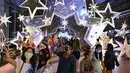 Orang-orang berfoto dengan dekorasi Natal di depan pusat perbelanjaan di Bangkok (21/12/2021). Menyambut Natal, dekorasi unik dan lucu ditampilkan di depan pusat perbelanjaan di Bangkok. (AFP/Lillian Suwanrumpha)