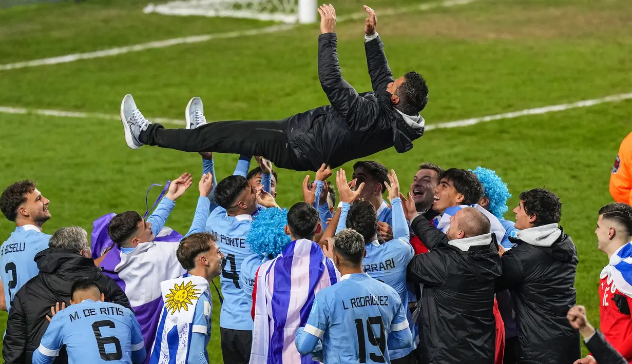 Pelatih Timnas Uruguay U-20, Marcelo Broli dilemparkan ke udara oleh para pemain dan ofisial tim dalam perayaan juara Piala Dunia U-20 2023 setelah mengalahkan Italia 1-0 pada laga final di Unico Diego Armando Maradona Stadium, La Plata, Argentina, Senin (12/6/2023) dini hari WIB. (AP Photo/Natacha Pisarenko)