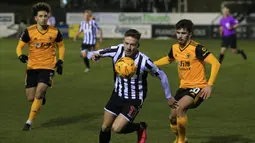 Gelandang Chorley, Elliot Newby (tengah) menguasai bola dibayangi gelandang Wolverhampton Wanderers, Vitinha dalam laga babak keempat Piala FA 2020/21 di Victory Park Stadium, Jumat (22/1/2021). Chorley kalah 0-1 dari Wolverhampton. (AFP/Lindsey Parnaby)