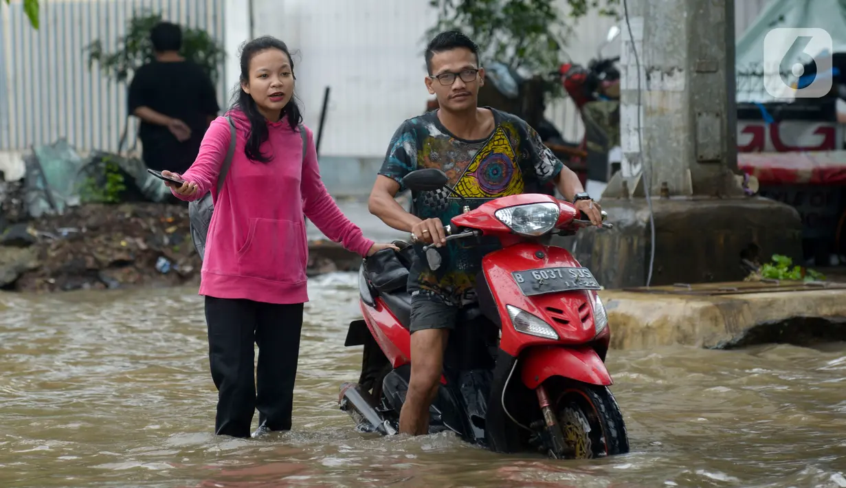 Pengendara sepeda motor menerjang banjir yang merendam Jalan Ahmad Yani, Jakarta, Sabtu (8/2/2020). Hujan yang mengguyur Jakarta sejak semalam membuat sejumlah ruas jalan terendam banjir. (merdeka.com/Imam Buhori)