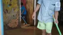 Warga membersihkan banjir yang merendam kawasan Rawajati, Jakarta Selatan, Sabtu (8/2/2020). Hujan yang terjadi semalaman menyebabkan Sungai Ciliwung kembali meluap hingga membuat rumah warga di kawasan tersebut terendam air setinggi 50 cm hingga 1 m. (Liputan6.com/Immanuel Antonius)
