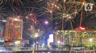 Warga menyaksikan pesta kembang api menyambut tahun baru 2023 di kawasan Bundaran HI, Jakarta, Senin (1/1/2023). Pemprov DKI Jakarta menggelar "car free night" hingga 1 Januari 2023 pukul 02.00 WIB dalam rangka menyambut tahun baru 2023. (Liputan6.com/Angga Yuniar)