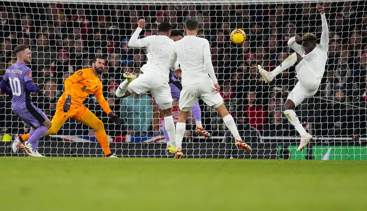 Pemain Arsenal, Bukayo Saka (kanan) berusaha mencetak gol ke gawang Liverpool saat laga putaran ketiga Piala FA 2023/2024 di Emirates Stadium, London, Inggris, Minggu (07/01/2024) WIB. Arsenal mengusung kampanye bertajuk 'No More Red' saat menggunakan jersey yang serba putih. (AP Photo/Kirsty Wigglesworth)