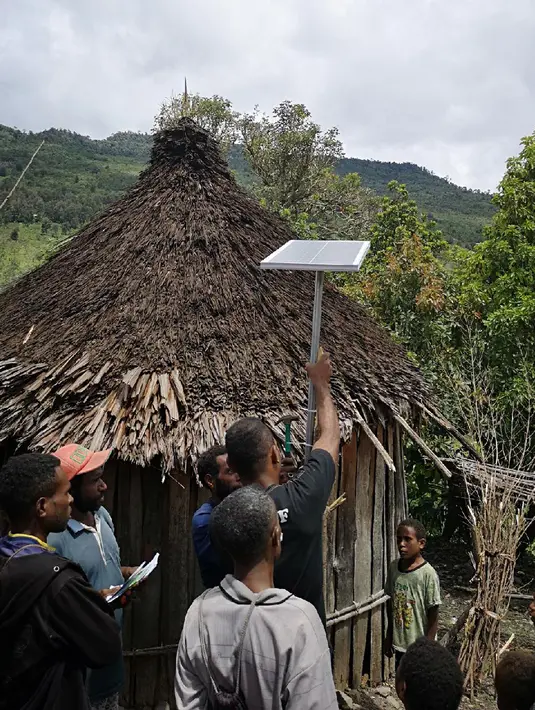 Warga memasang Lampu Tenaga Surya Hemat Energi (LTSHE) di Distrik Puldama, Kabupaten Yahukimo, Provinsi Papua. Keberadaan LTSHE mengubah malam gulita  menjadi benderang. (Liputan6.com/HO/Hadi M Juraid)