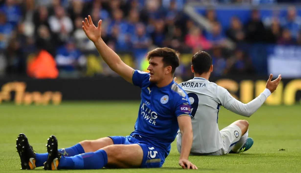 Bek Leicester, Harry Maguire, terjatuh saat berebut bola dengan striker Chelsea, Alvaro Morata, pada laga Premier League di Stadion King Power, Leicester, Sabtu (9/9/2017). Leicester kalah 1-2 dari Chelsea. (AFP/Ben Stansall)