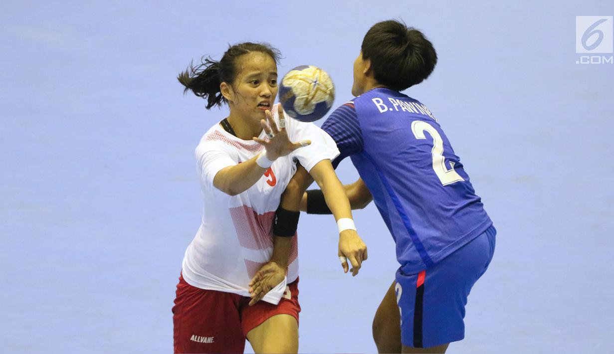 Pemain bola tangan putri Indonesia, Lia Apriliani (kiri) mencoba melewati adangan pemain Thailand, Pawinee Bunjarern pada babak penyisihan grup B Asian Games 2018 di Jakarta, Kamis (16/8). Indonesia kalah 16-34. (Liputan6.com/Helmi Fithriansyah)