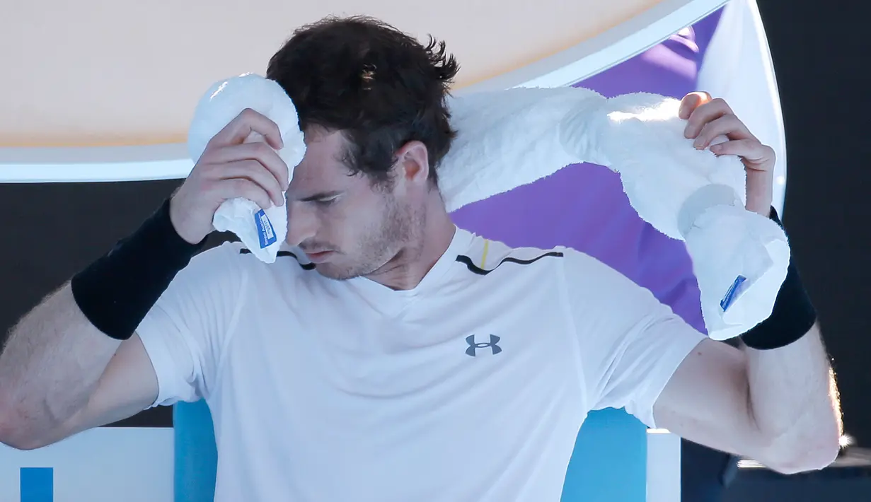 Petenis asal Inggris, Andy Murray meletakkan handuk berisi es di keningnya saat istirahat dalam pertandingan Australia Terbuka di Melbourne, Australia, (22/1). Teriknya cuaca di Australia Terbuka, membuat para pemain kepanasan. (AP Photo/Aaron Favila)