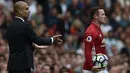 Wayne Rooney (kanan) dan pelatih Manchester City, Pep Guardiola terlibat insiden berebut bola pada laga Premier League di Old Trafford, Manchester,  (10/9/2016). (AFP/Oli Scarff)