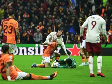 Kiper Galatasaray Fernando Muslera memegang bola di depan gelandang Manchester United Facundo Pellistri pada matchday kelima Grup A Liga Champions di Rams Global Stadyumu, Kamis (30/11/2023) dini hari WIB. (YASIN AKGUL / AFP)