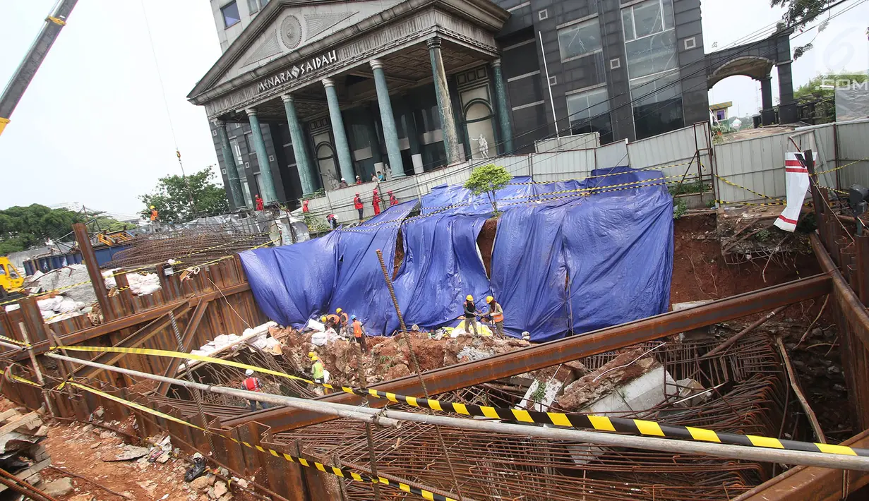 Pekerja konstruksi merapikan lereng galian pondasi pembangunan tiang pancang proyek LRT dan flyover Pancoran yang longsor di Jakarta, Jumat (13/10). (Liputan6.com/Immanuel Antonius)
