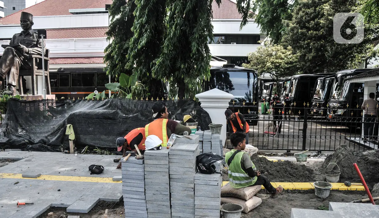 Pekerja menyelesaikan proyek revitalisasi trotoar di Jalan Medan Merdeka Selatan, Jakarta Pusat, Selasa (22/11/2022). Kepala Dinas Bina Marga DKI Jakarta Hari Nugroho mengatakan Rp 171 miliar RAPBD DKI Jakarta 2023 untuk membangun sekitar 20 kilometer trotoar di Ibu Kota. (merdeka.com/Iqbal S. Nugroho)