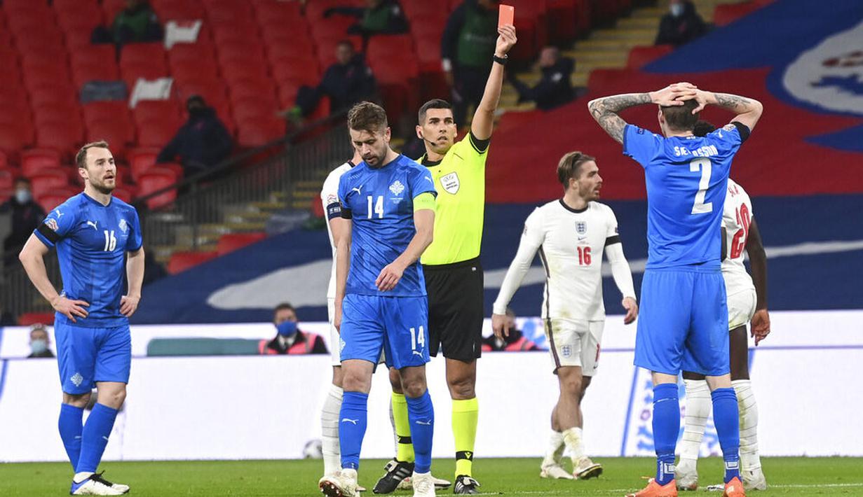 Wasit memberikan kartu merah kepada pemain Islandia, Birkir Saevarsson, saat melawan Inggris pada laga UEFA Nations League di Stadion Wembley, Kamis (19/11/2020). Inggris menang dengan skor 4-0. (Michael Regan/Pool via AP)