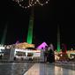 Orang-orang melewati bangunan masjid Faisal yang diterangi selama perayaan hari kelahiran Nabi Muhammad SAW atau Maulid Nabi di Islamabad, Pakistan, Senin (18/10/2021). Peringatan Maulid Muhammad tak hanya diperingati umat Islam di Indonesia, tapi juga di berbagai negara. (Farooq NAEEM/AFP)