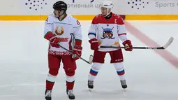 Presiden Rusia Vladimir Putin (kanan) dan Presiden Belarus Alexander Lukashenko (kiri) ikut serta dalam pertandingan hoki es di Shayba Arena, Resor Laut Hitam Sochi, Rusia, (15/2). (Sergei Chirikov / Pool / AFP)