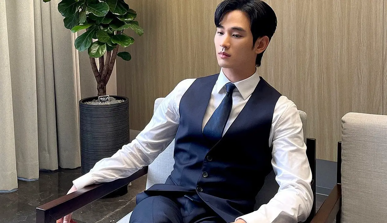Gaya gentleman Kim Soo Hyun dibalut kemeja lengan panjang putih dan setelan vest dan celana panjang biru navy, ditambah dasi bernuansa senada. [Foto: Instagram/soohyun_k216]