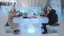 Foto yang diambil 13 Januari 2020 menunjukkan orang-orang menikmati hot pot di meja dan kursi berukir es di dalam igloo selama Festival Es dan Salju Internasional Harbin tahunan.  Restoran berbentuk rumah salju bangsa Eskimo ini hadir untuk memberikan sensasi makan malam yang berbeda. (STR/AFP)