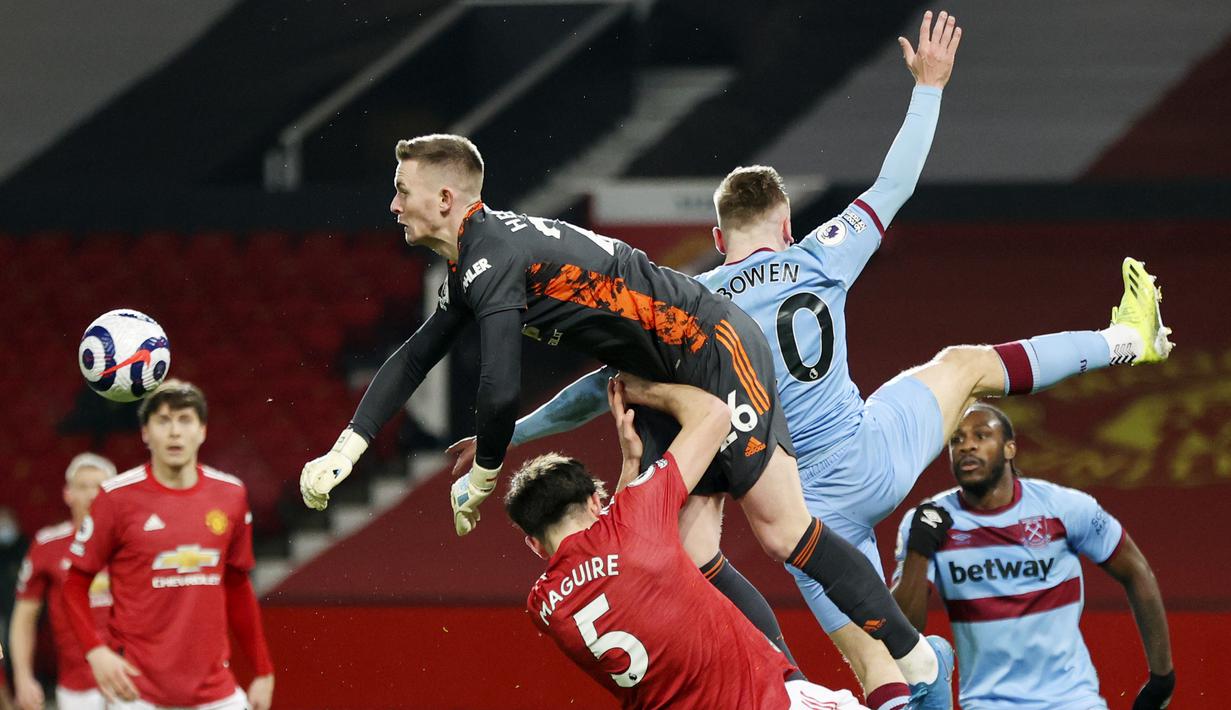 Kiper Manchester United, Dean Henderson, berusaha menghalau bola saat melwan West Ham United pada laga Liga Inggris di Stadion Old Trafford, Minggu (15/3/2021). Setan Merah menang dengan skor 1-0. (AP/Clive Brunskill,Pool)
