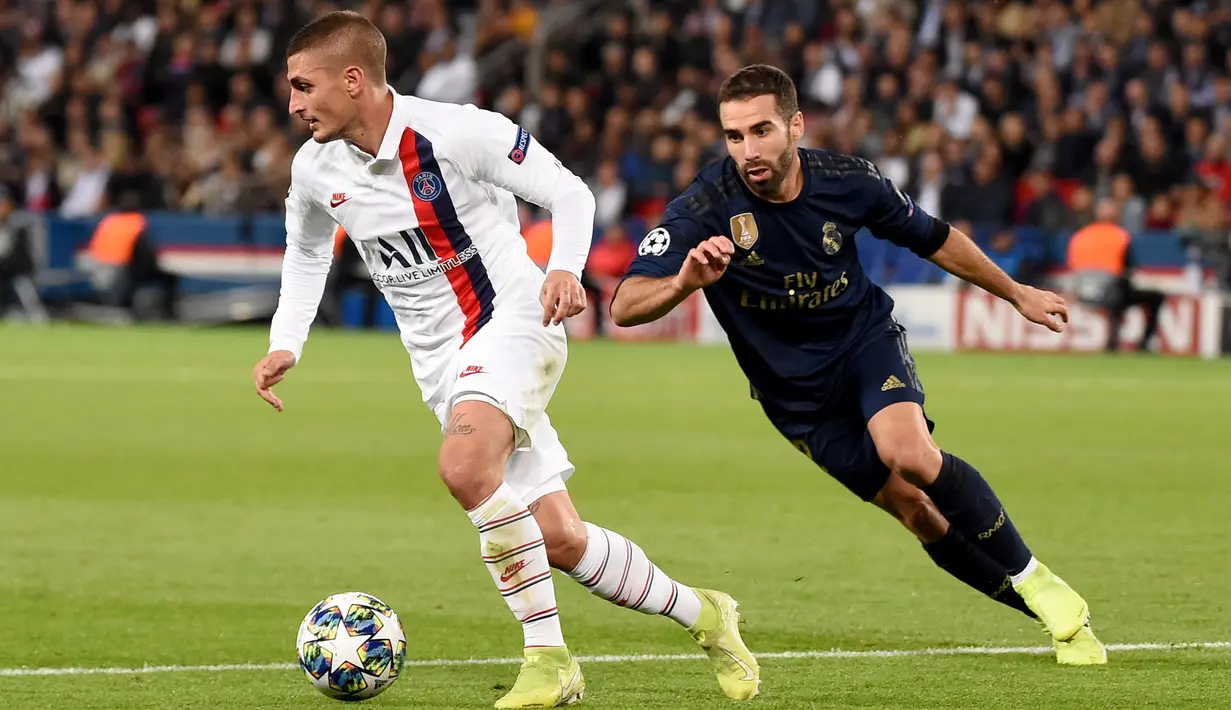 Gelandang Paris Saint-Germain (PSG), Marco Verratti (berebut bola dengan pemain belakang Real Madrid, Dani Carvajal dalam laga Grup A Liga Champions di Parc des Princes, Rabu (18/9/2019). PSG berhasil menaklukkan tamunya Real Madrid 3-0. (Lucas BARIOULET / AFP)