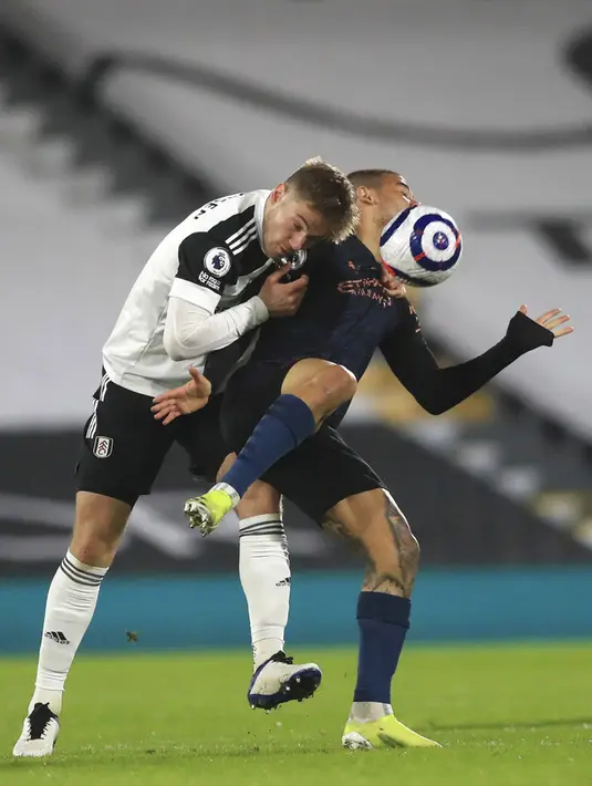 Pemain Fulham Joachim Andersenm (kiri) memperebutkan bola dengan pemain Manchester City Gabriel Jesus pada pertandingan Liga Inggris di Stadion Craven Cottage, London, Inggris, Sabtu (13/3/2021). Manchester City menang 3-0. (Adam Davy/Pool via AP)