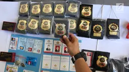 Resmob Ditreskrimum Polda Metro Jaya menunjukkan barang bukti kasus pemalsuan, penipuan, dan kepemilikan senjata api di Jakarta, Kamis (15/3). Petugas menangkap SK, pelaku penipuan yang mengaku Staf Khusus Kepresidenan. (Liputan6.com/Arya Manggala)