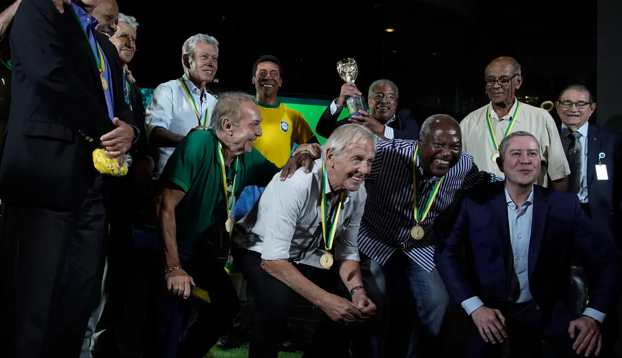 Mantan pemain legendaris Brasil dan presiden CBF Rogerio Caboclo berfoto dengan patung Pele di Museum Tim Sepak Bola Brasil di Rio de Janeiro, Kamis (20/2/2020). Konfederasi Sepak Bola Brasil meluncurkan patung Pele sebagai bagian dari peringatan 50 tahun kemenangan Piala Dunia 1970. (AP/Leo Correa)