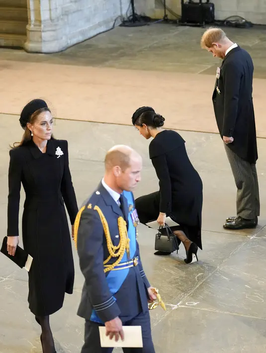 <p>Meghan Markle dan Pangeran Harry memberikan penghormatan dalam prosesi persemayaman Ratu Elizabeth II di Westminster Hall, 14 September 2022. (Foto: Christopher Furlong/Pool Photo via AP)</p>