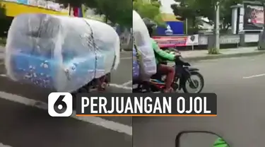 Beredar video memperlihatkan pengemudi ojek online memgangkut kasur dengan motor.