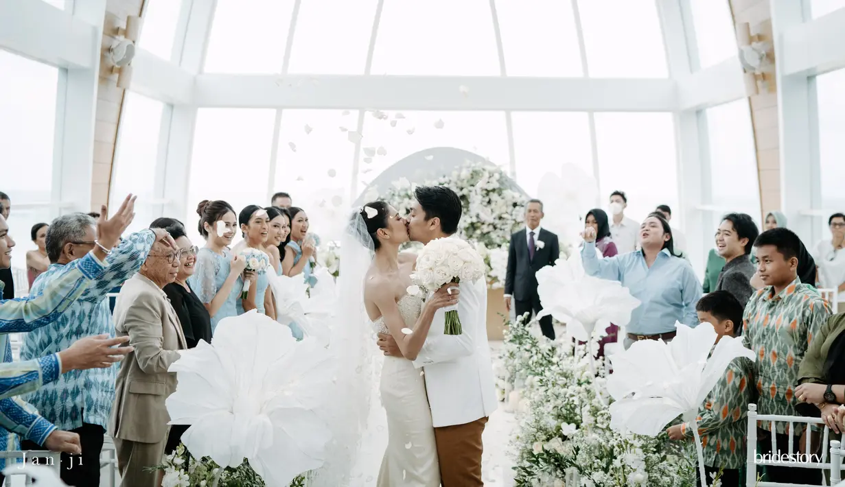 Begitu juga pemilihan aksesori, Mikha memilih gaya minimalis. Hanya dengan cincin kawin dan tiara di kepala. Beda dengan sang mama yang saat itu memilih anting panjang yang menjuntai. [@thebridestory]