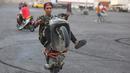 Seorang pemuda memamerkan keterampilannya mengendarai sepeda motor di Distrik Jadriya, Baghdad, Irak, 6 Agustus 2021. Banyak pemuda Irak di Baghdad berusaha untuk menjadi modern, bahkan ketika mereka mengakui negaranya mungkin tidak memiliki masa depan. (AHMAD AL-RUBAYE/AFP)