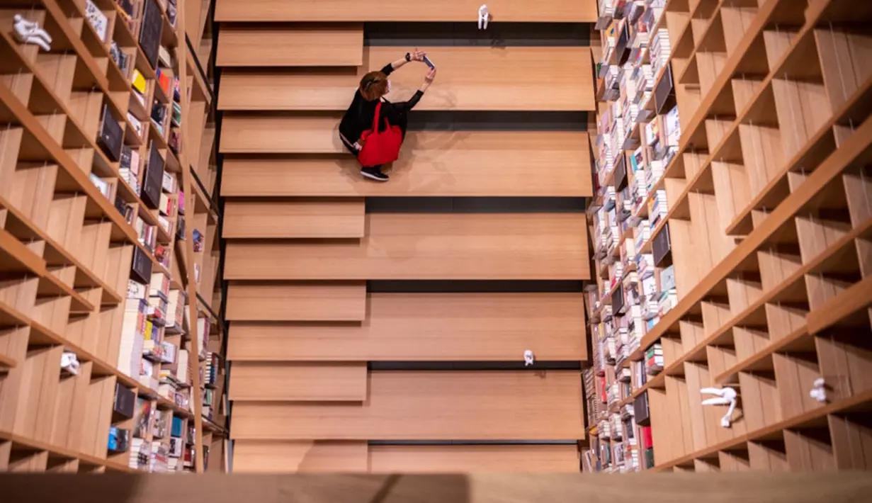 Reporter mengambil gambar saat pratinjau media dalam Rumah Sastra Internasional Waseda di Universitas Waseda, Tokyo, Jepang, 22 September 2021. Rumah Sastra Internasional Waseda yang juga dikenal sebagai Perpustakaan Haruki Murakami dirancang oleh arsitek Jepang, Kengo Kuma. (Philip FONG/AFP)