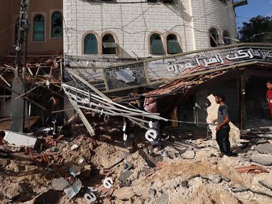 Orang-orang memeriksa dampak dari serangan Israel di Khan Yunis, Jalur Gaza Selatan pada 14 Mei 2025. (Eyad BABA/AFP)