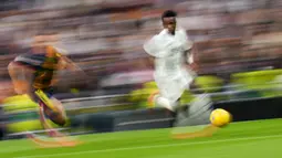Pemain Real Madrid, Vinicius Junior menggiring bola melewati pemain Girona dalam laga lanjutan Liga Spanyol 2024/2025 di Santiago Bernabeu Stadium, Madrid, Minggu (23/02/2025) waktu setempat. (AP Photo/Manu Fernandez)