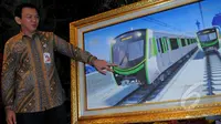 Gubernur Basuki Tjahaja Purnama memperlihatkan lukisan kereta api saat menghadiri penandatangan kontrak antara PT MRT Jakarta dengan Sumitomo Corp di Balaikota, Jakarta, Selasa (3/3/2015).(Liputan6.com/Faisal R Syam)