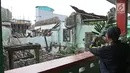 Seorang pria mengambil gambar reruntuhan bangungan SMPN 32 Pekojan Jakarta Barat yang roboh pada Kamis (21/12). Akibat peristiwa ini, dikabarkan tiga orang terluka. Dua di antaranya terkena serpihan reruntuhan bangunan. (Liputan6.com/Herman Zakharia)