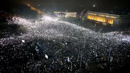 Pengunjuk rasa berkumpul di pusat Bucharest merayakan kemenangan tuntutan mereka, Rumania, Minggu (5/2). Pengunjuk rasa menuntut Pemerintah Rumania untuk membatalkan UU Korupsi. (AP Photo)