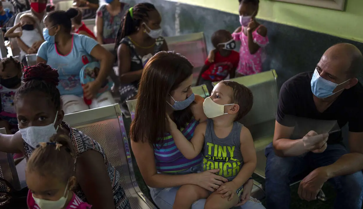 Orang tua menunggu bersama anak mereka untuk menerima dosis vaksin COVID-19 Soberana-02 di sebuah klinik di Havana, Kuba, Kamis (17/9/2021). Pemerintah Kuba memulai vaksinasi Covid-19 bagi anak-anak berusia 2 tahun dengan vaksin buatan dalam negeri. (AP Photo/Ramon Espinosa)