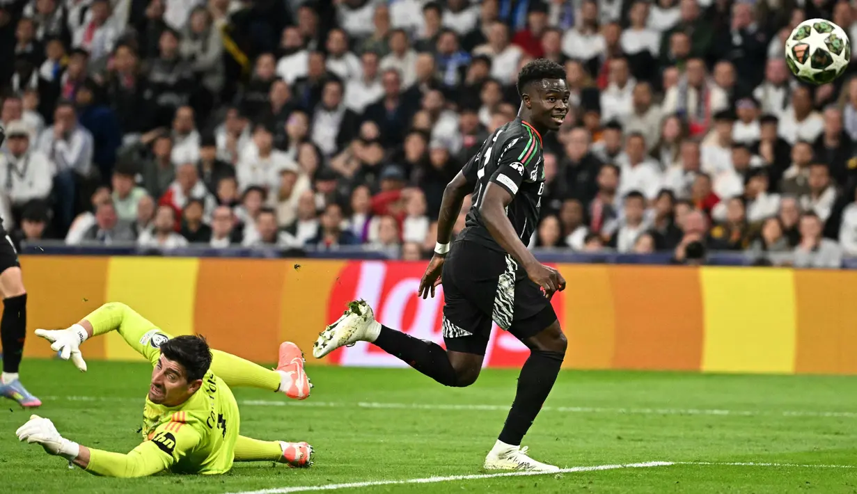 Di babak kedua, pada menit ke-65, The Gunners membuka keunggulan lewat aksi Bukayo Saka yang berhasil mengecoh penjaga gawang Los Blancos, Thibaut Courtois. (JAVIER SORIANO/AFP)