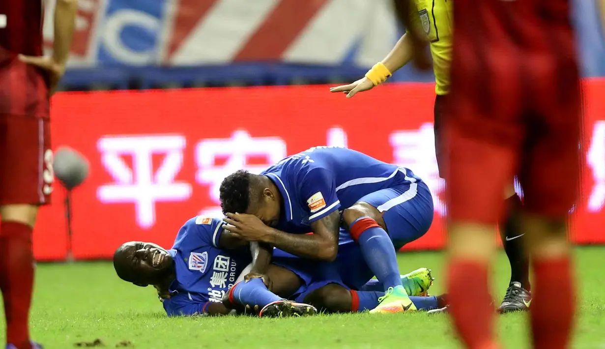 Demba Ba saat dibantu rekannya saat kesakitan usai kakinya patah akibat hantaman di kaki kirinya oleh bek Shanghai SIPG, Sun Xiang di laga derby melawan Shanghai SIPG di Liga Super China, (17/7).  (PHOTO/STR/Cina OUT)