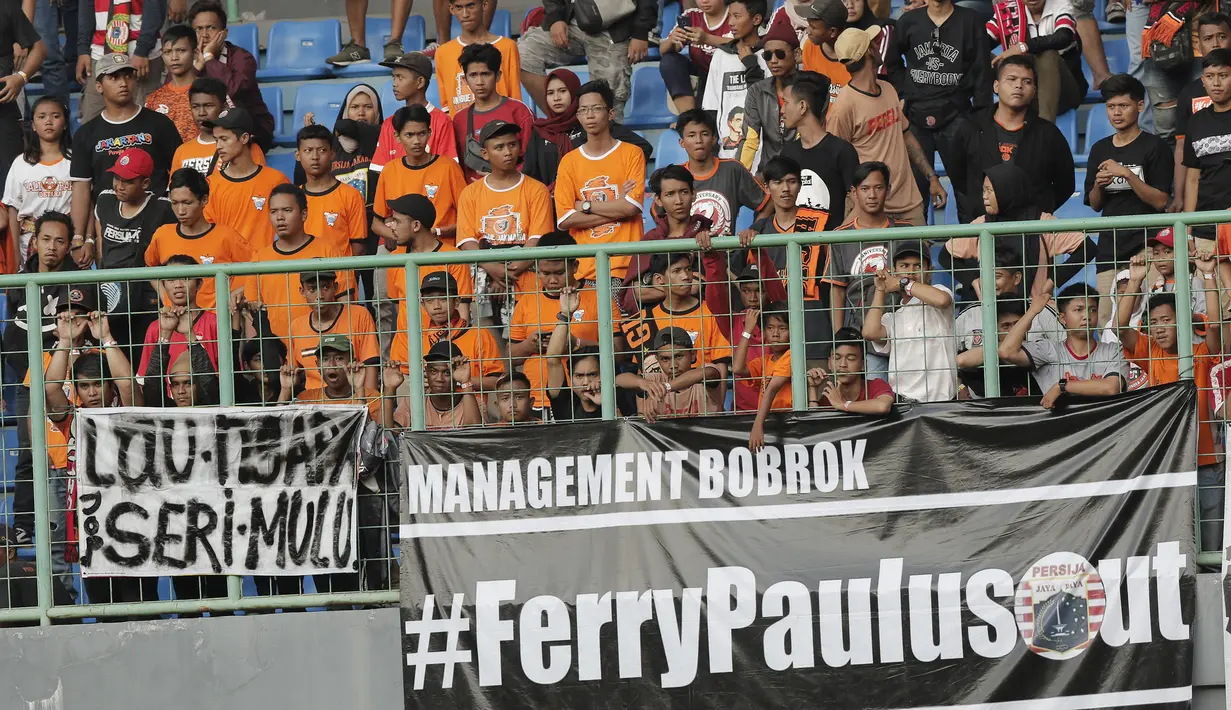 Suporter Persija Jakarta memasang spanduk protes saat pertandingan melawan Perseru Badak Lampung pada laga Liga 1 2019 di Stadion Patriot, Bekasi, Minggu (1/9). Persija takluk 0-1 dari Badak Lampung. (Bola.com/M Iqbal Ichsan)