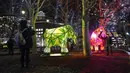 Orang-orang memotret "Permafrost - Sleeping Giants" karya Fisheye, sebagai bagian dari festival Winter Lights di Canary Wharf, di London, Rabu (18/1/2023). Festival ini menerangi Canary Wharf dengan koleksi spektakuler lebih dari 20 instalasi. (AP Photo/Alberto Pezzali)