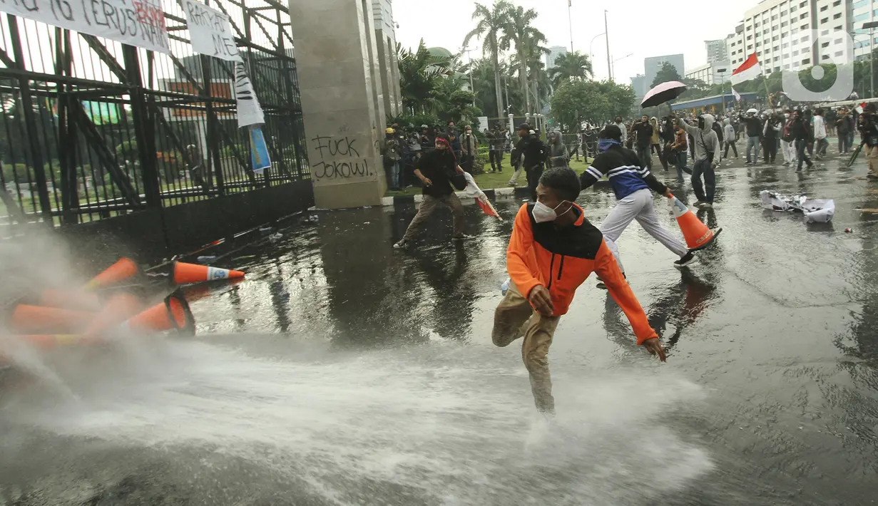 Aparat kepolisian melepaskan water canon untuk membubarkan massa aksi demo mahasiswa di depan Gedung DPR, Jakarta, Senin (11/4/2022). Mahasiswa yang tergabung dalam aliansi BEM SI menggelar unjuk rasa besar-besaran di depan Gedung DPR/MPR RI, Senin ini. (Liputan6.com/Angga Yuniar)