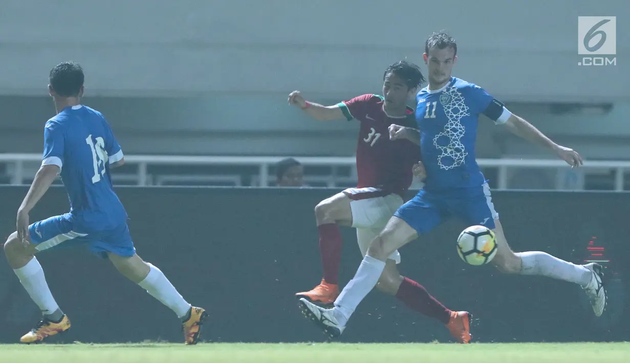 Bek Indonesia U-23, Gavin Kwan Adsit (tengah) mencoba menerobos kawalan pemaian Uzbekistan saat laga PSSI Anniversary 2018 di Stadion Pakansari, Kab Bogor, Kamis (3/5). Laga imbang 0-0. (Liputan6.com/Helmi Fithriansyah)