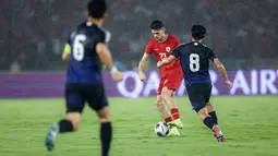 Pemain Timnas Indonesia, Justin Hubner (tengah) mengontrol bola dibayangi pemain Jepang, Takumi Minamino pada laga lanjutan putaran ketiga Grup C Kualifikasi Piala Dunia 2026 di Stadion Utama Gelora Bung Karno (SUGBK), Senayan, Jakarta, Jumat (15/11/2024). (Bola.com/Bagaskara Lazuardi)