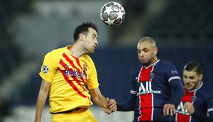 Pemain Paris Saint-Germain, Layvin Kurzawa, duel udara dengan pemain Barcelona, Sergio Busquets, pada laga Liga Champions di Stadion Parc des Princes, Kamis (11/3/2021). Kedua tim bermain imbang 1-1. (AP/Christophe Ena)