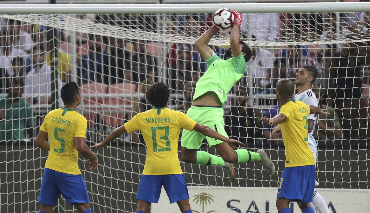 Kiper Brasil, Alisson, menangkap bola saat melawan Argentina pada laga persahabatan di Stadion King Abdullah, Jeddah, Selasa (16/10/2018). Brasil menang 1-0 atas Argentina. (AP/STR)